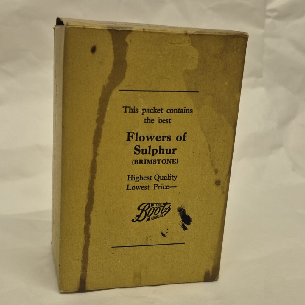 Worn cardboard box with navy blue text which reads 'This packet contains Flowers of Sulphur (Brimstone) Highest Quality, lowest price' Beneath this is the classic Boots logo.