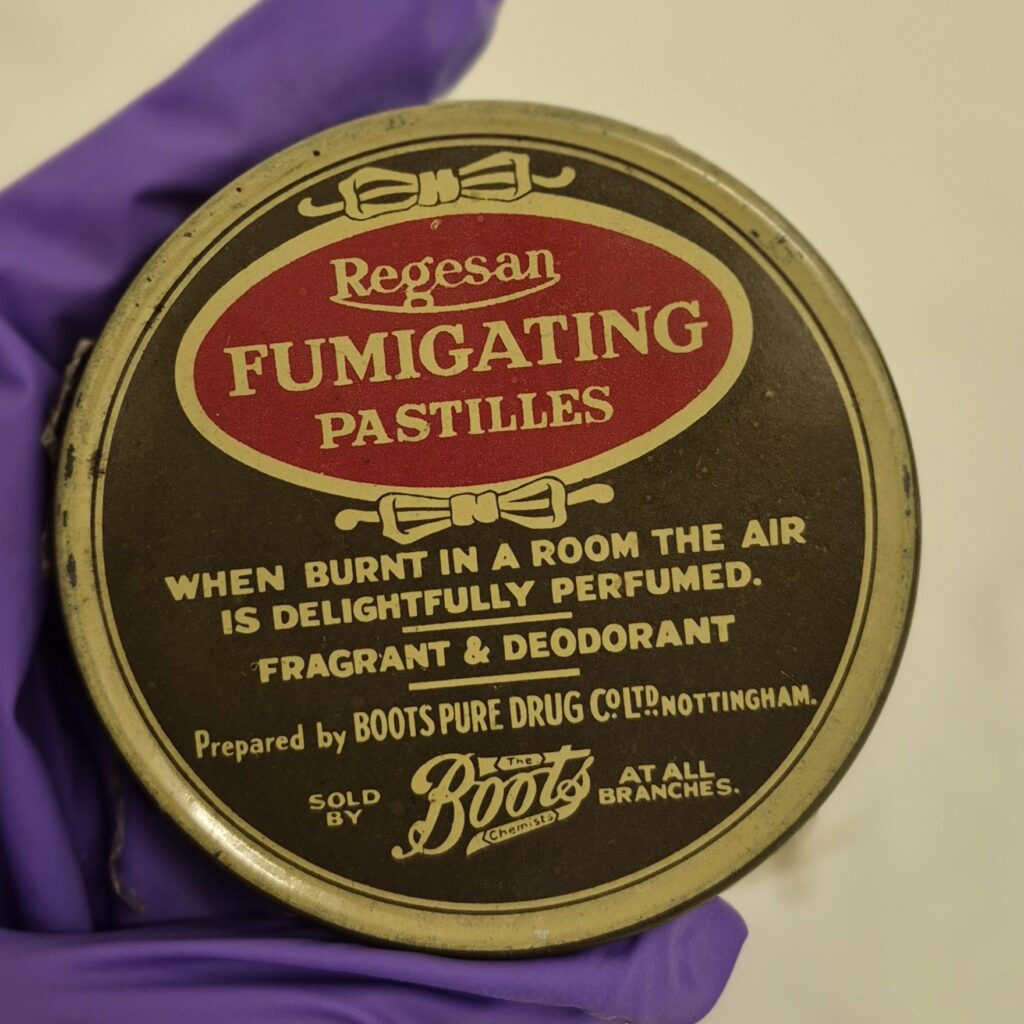 Circular tin with brown background and cream text and border. Red oval with cream text reads 'Regesan Fumigating Pastilles'
Further text gives instructions and show the Botts Chemists logo.
