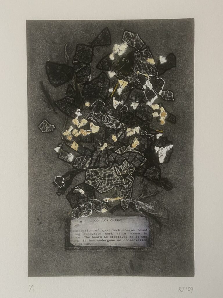 An abstract print of black, white, grey and yellow abstract triangular shapes spread across a grey background. At the bottom a rectangular label is pasted which reads "GOOD LUCK CHARMS. Collection of good luck charms found during renovation work at a house in Linton. The hoard is displayed as it was found, it has undergone no conservation work so far.